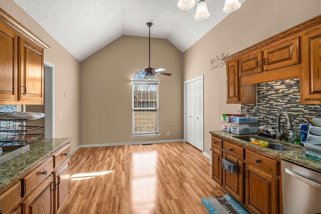 kitchen with a sink, light wood finished floors, brown cabinets, and stainless steel dishwasher