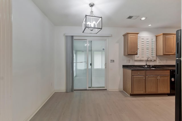 kitchen with light wood finished floors, baseboards, visible vents, and a chandelier