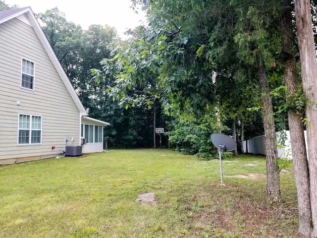 view of yard with central AC and fence