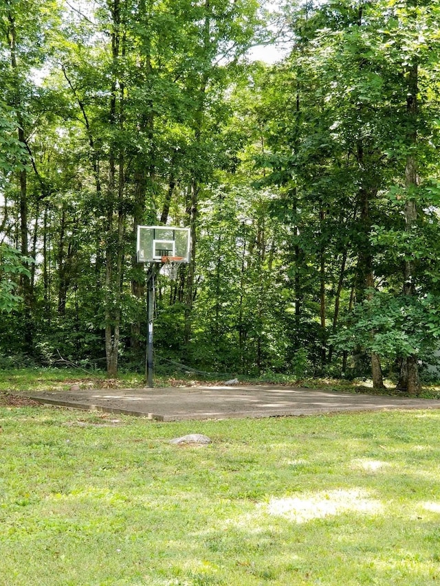 view of sport court with basketball court and a lawn