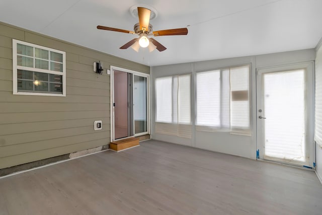 unfurnished sunroom featuring ceiling fan