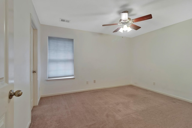 empty room with baseboards, visible vents, and light colored carpet