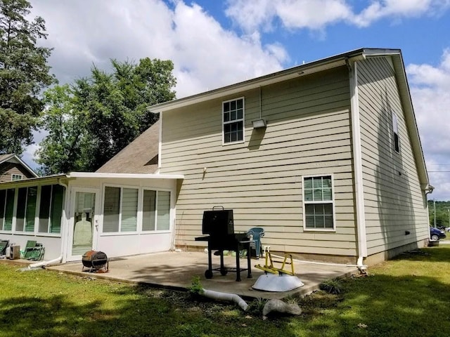 rear view of property with a sunroom, a patio, and a lawn