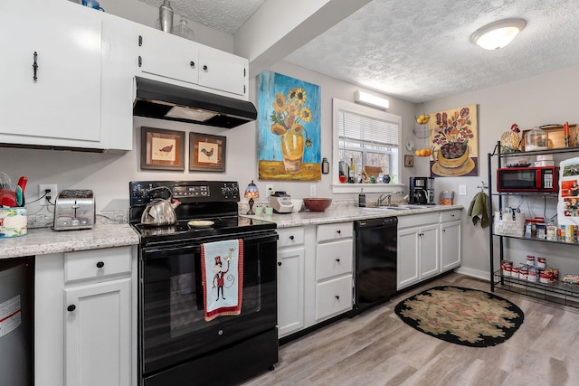 kitchen with black appliances, under cabinet range hood, and a textured ceiling