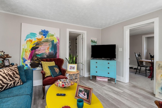 living room with a textured ceiling, wood finished floors, and crown molding