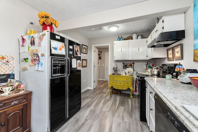 kitchen with a textured ceiling, under cabinet range hood, white cabinetry, light wood-style floors, and black appliances