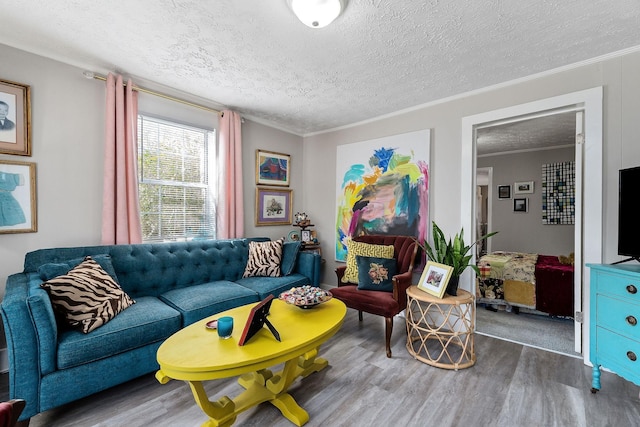 living area with a textured ceiling, crown molding, and wood finished floors