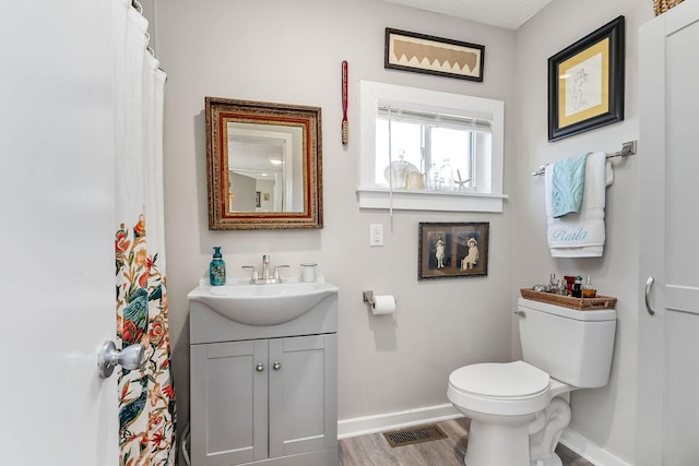 full bathroom with toilet, wood finished floors, visible vents, and baseboards