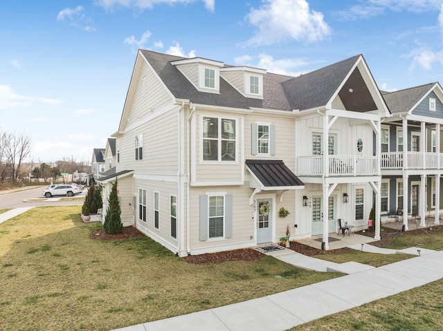 view of front facade with a patio area, french doors, board and batten siding, a front lawn, and a shingled roof