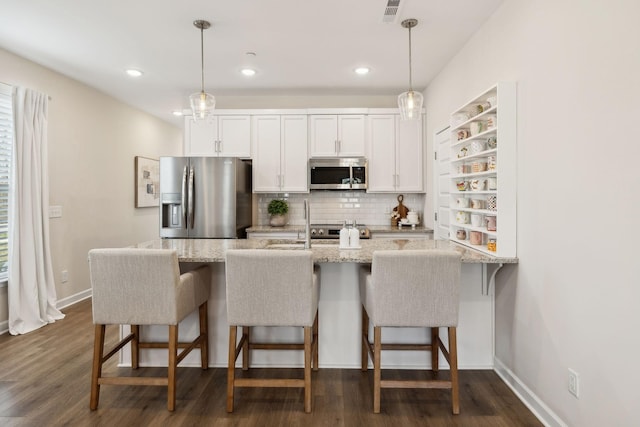 kitchen with dark wood-type flooring, visible vents, white cabinetry, appliances with stainless steel finishes, and backsplash