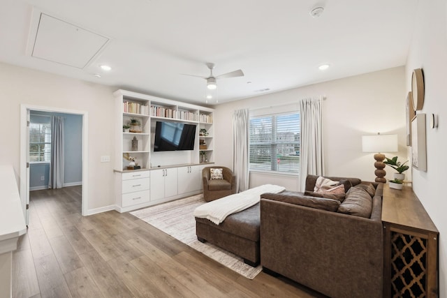 living room featuring recessed lighting, a ceiling fan, baseboards, light wood finished floors, and attic access