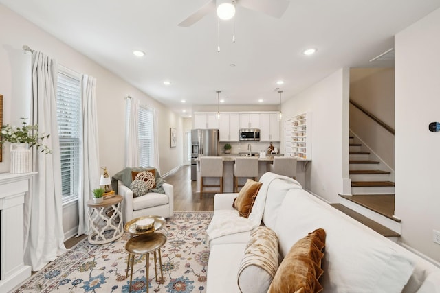 living area featuring stairs, recessed lighting, a ceiling fan, and wood finished floors