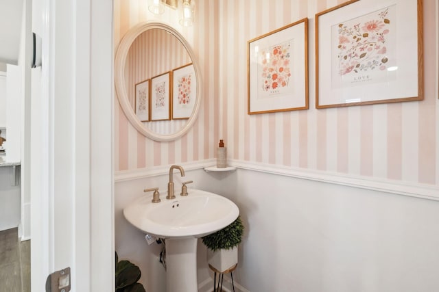 bathroom with a sink and wallpapered walls