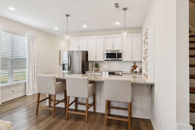 kitchen featuring visible vents, white cabinets, dark wood finished floors, appliances with stainless steel finishes, and backsplash