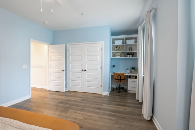 unfurnished bedroom with a closet, ceiling fan, baseboards, and wood finished floors