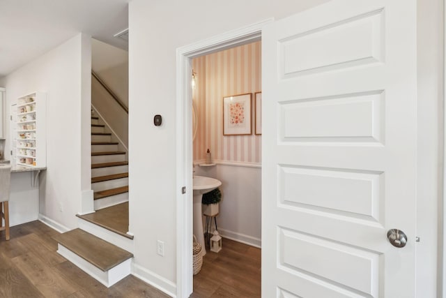 stairway with wood finished floors and baseboards