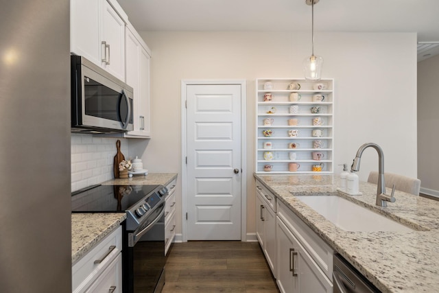 kitchen with a sink, white cabinetry, appliances with stainless steel finishes, backsplash, and dark wood finished floors