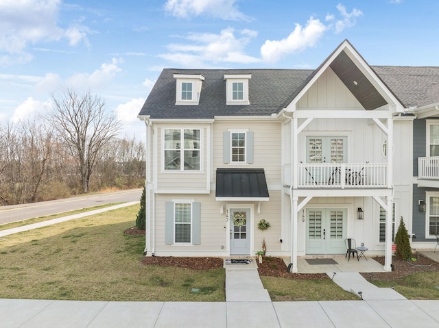 view of front of property with roof with shingles, french doors, board and batten siding, and a front yard