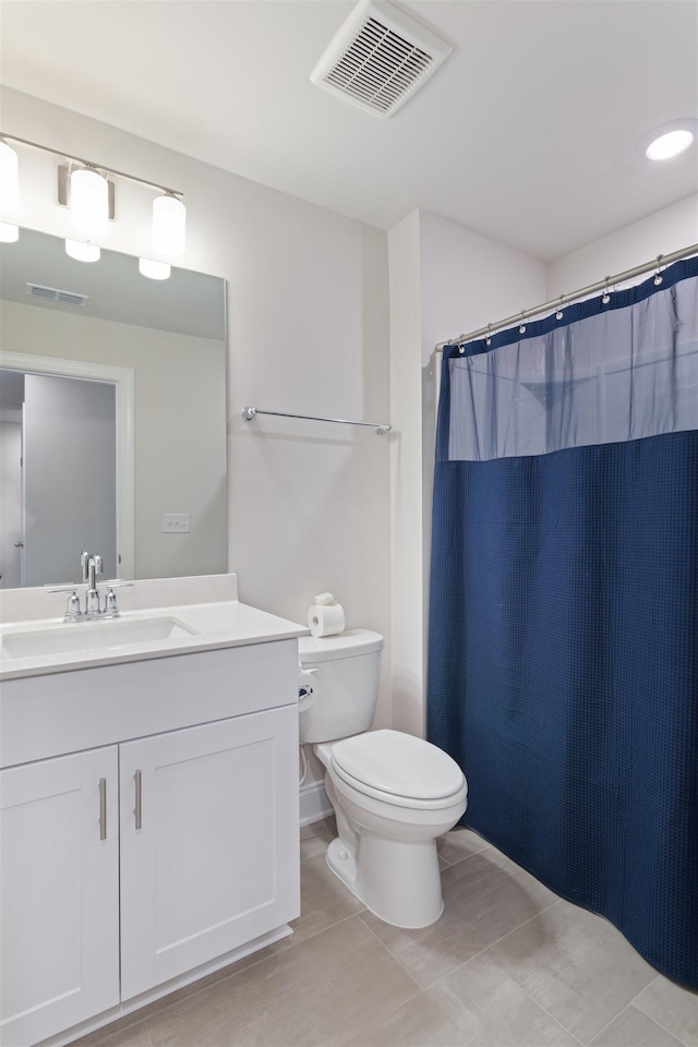 bathroom featuring a shower with curtain, visible vents, vanity, and toilet