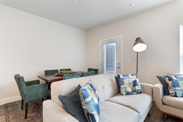 living area with baseboards and wood finished floors