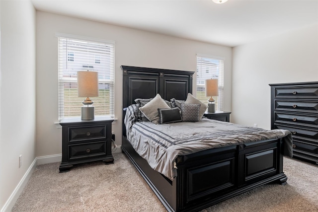 bedroom featuring baseboards and light colored carpet