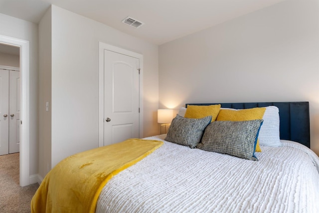 carpeted bedroom featuring a closet and visible vents