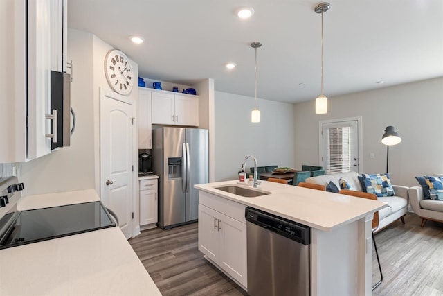 kitchen featuring dark wood-style floors, stainless steel appliances, open floor plan, white cabinetry, and a sink