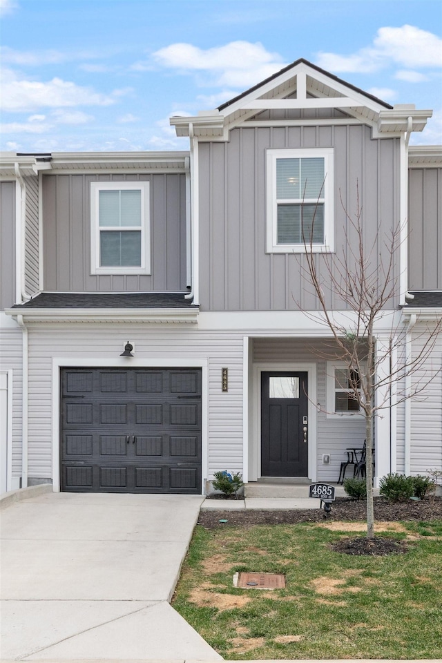 view of front of home featuring a garage, concrete driveway, a front lawn, and board and batten siding