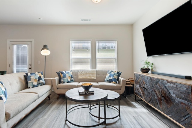 living area featuring light wood-type flooring and visible vents