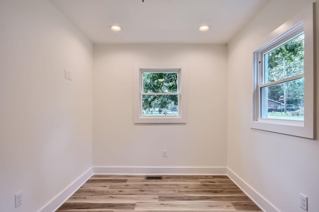 empty room with recessed lighting, light wood-type flooring, and baseboards