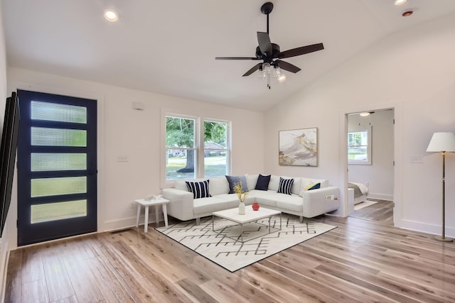 living area with lofted ceiling, light wood-style floors, and a wealth of natural light