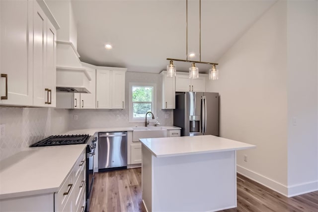 kitchen featuring tasteful backsplash, appliances with stainless steel finishes, light countertops, white cabinetry, and a sink