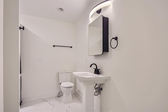 half bath featuring marble finish floor, baseboards, and toilet