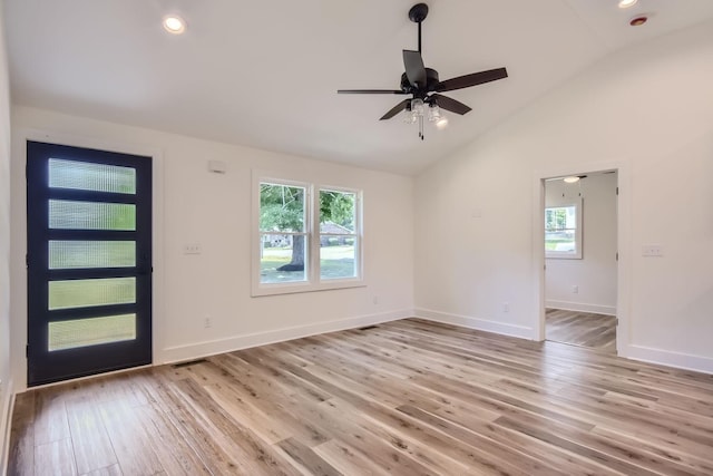 entrance foyer featuring light wood finished floors, plenty of natural light, baseboards, and vaulted ceiling