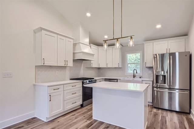 kitchen featuring custom exhaust hood, stainless steel appliances, light countertops, backsplash, and white cabinets