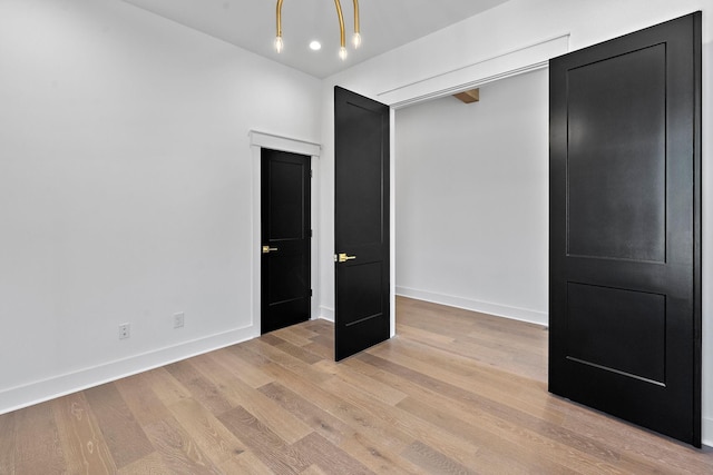 unfurnished bedroom featuring light wood-type flooring and baseboards