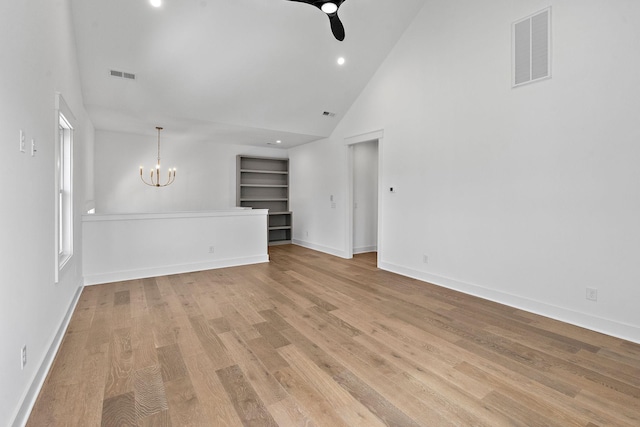 empty room with visible vents, light wood-style flooring, baseboards, and an inviting chandelier