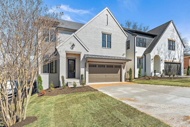 french country style house with brick siding, concrete driveway, a front yard, a standing seam roof, and a garage