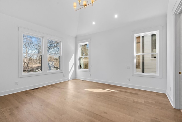 empty room featuring baseboards, visible vents, an inviting chandelier, vaulted ceiling, and light wood-style floors