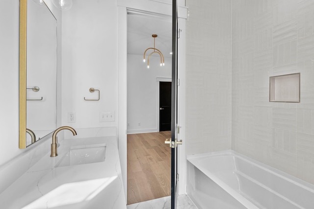 full bath featuring a sink and wood finished floors