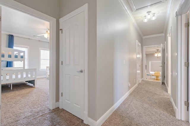 corridor featuring baseboards, carpet flooring, and crown molding