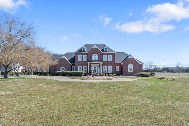 colonial home featuring brick siding and a front lawn