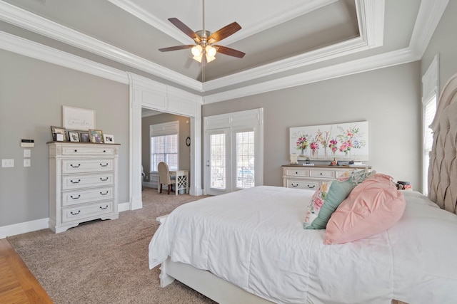 bedroom featuring baseboards, ceiling fan, a tray ceiling, and crown molding