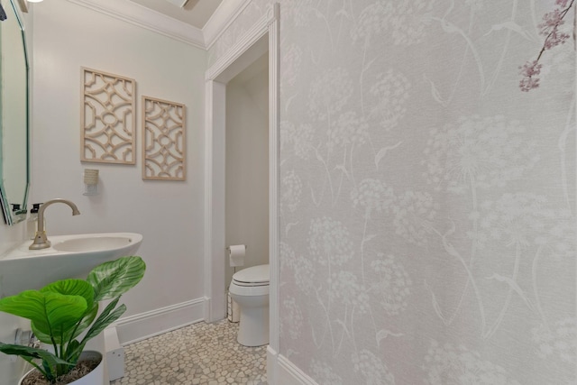 bathroom featuring baseboards, toilet, ornamental molding, tile patterned floors, and a sink