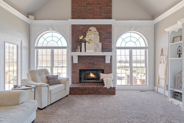 living area featuring a fireplace, high vaulted ceiling, and a wealth of natural light