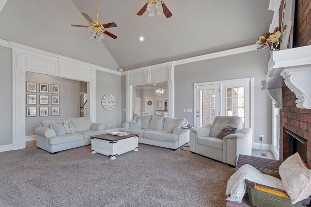 living room with carpet floors, stairway, a brick fireplace, high vaulted ceiling, and ceiling fan with notable chandelier