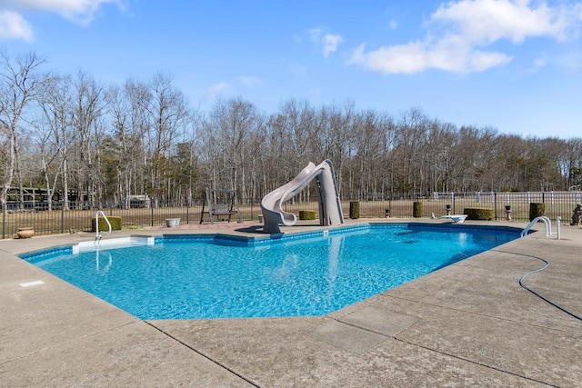 view of swimming pool featuring a water slide, a patio area, fence, and a fenced in pool