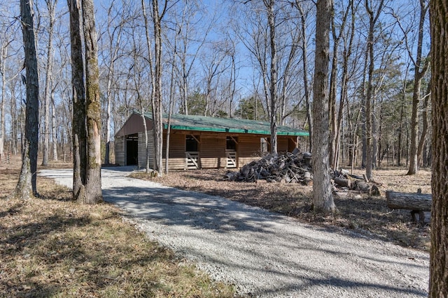 chalet / cabin featuring a porch and gravel driveway