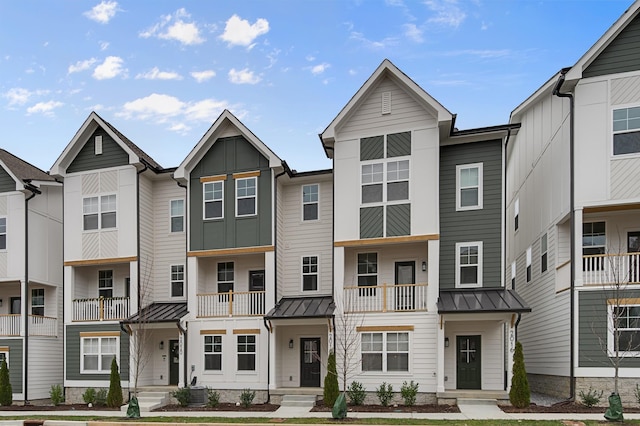 townhome / multi-family property with a standing seam roof, central AC, metal roof, and board and batten siding