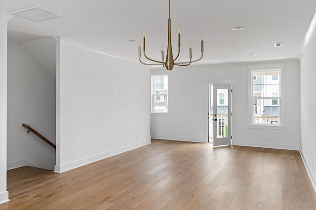 interior space with baseboards, ornamental molding, light wood-type flooring, and an inviting chandelier